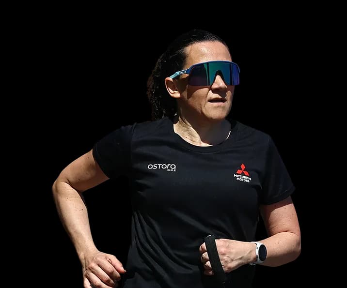 Macarena Larraín corriendo con lentes de sol y polera de competencia
